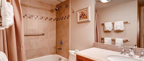 Un baño con bañera, inodoro y lavamanos.