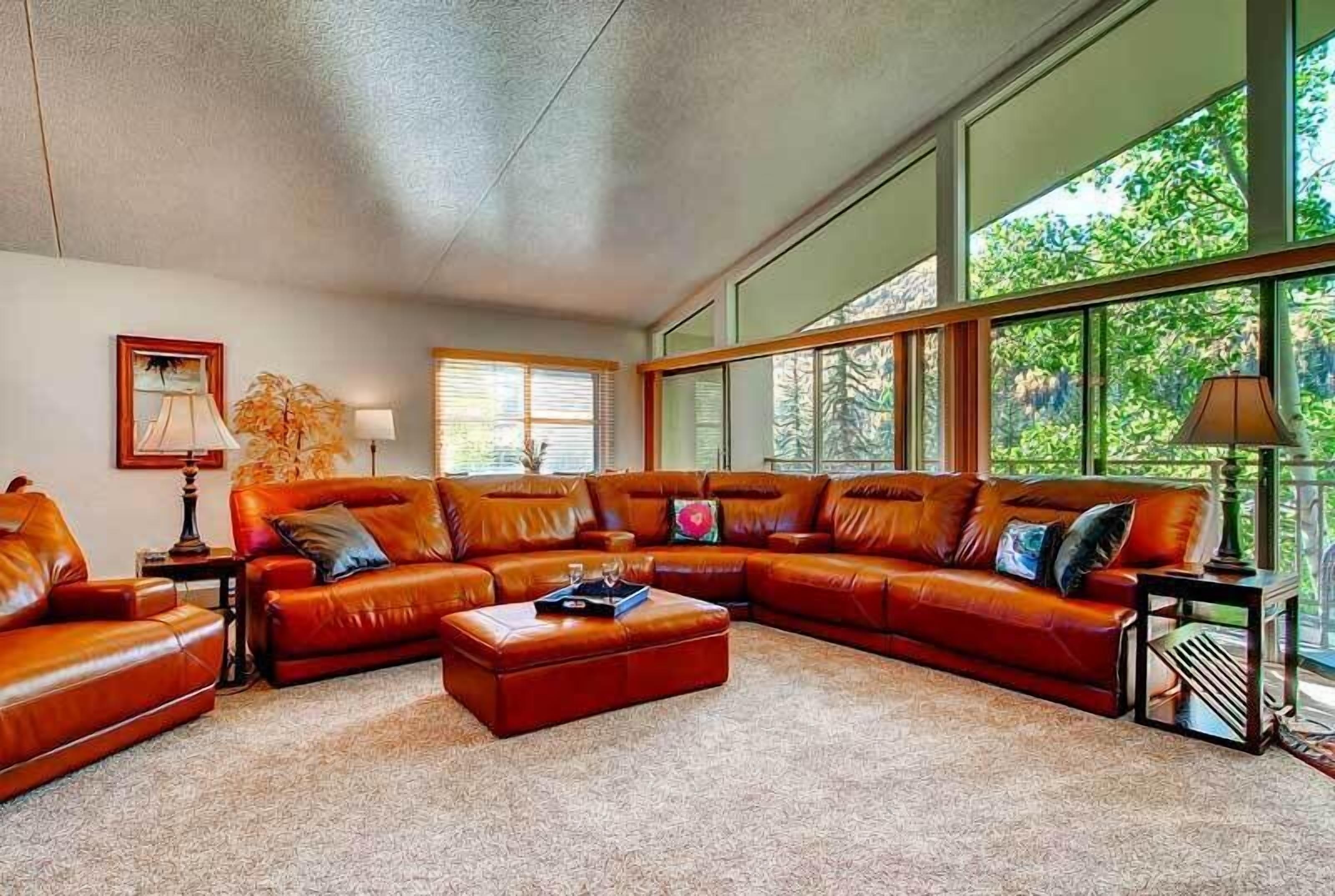 A spacious living room with a large sectional sofa, a coffee table, and a fireplace.