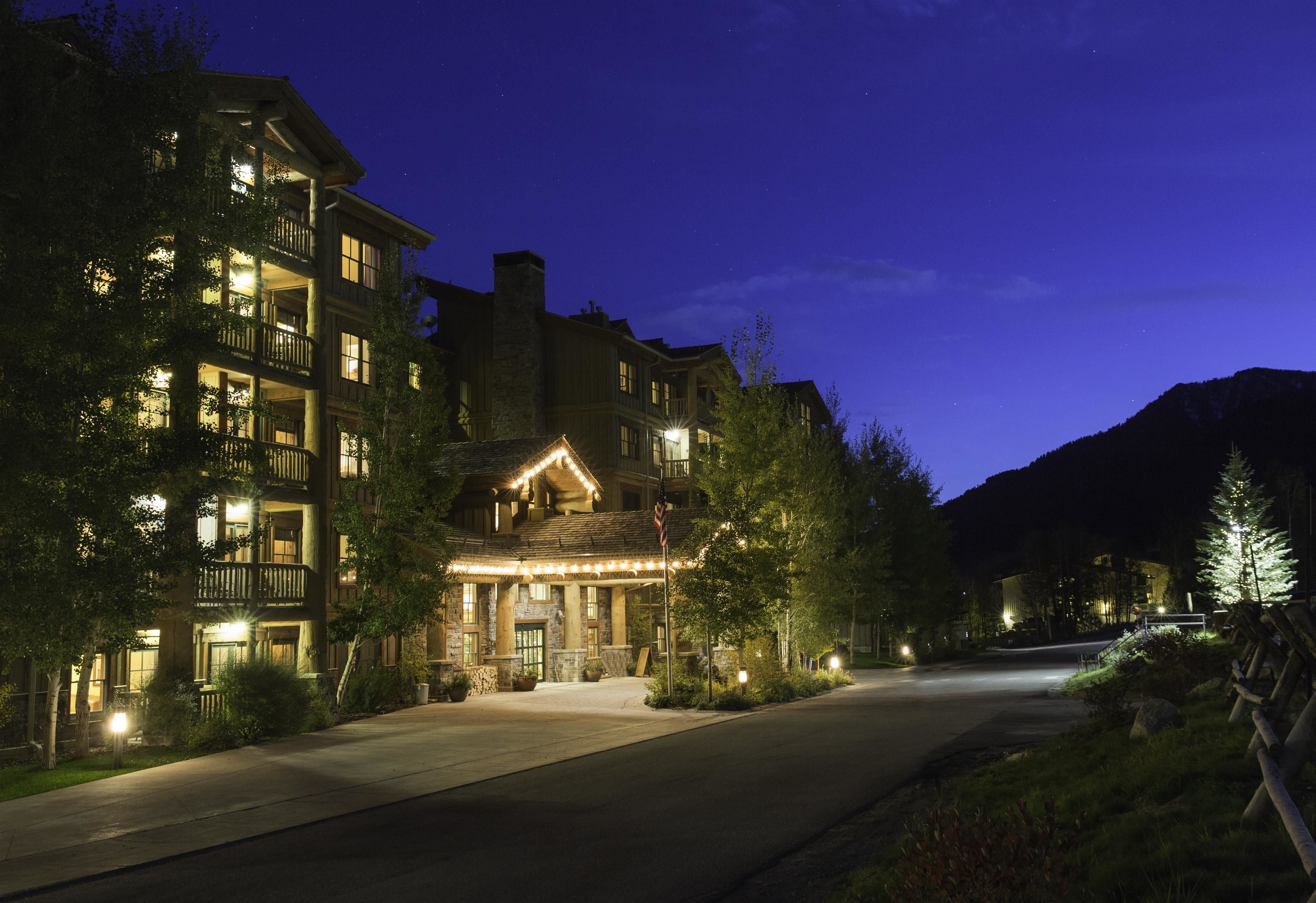 A multi-story hotel with a prominent entrance, large windows, and a well-lit facade.