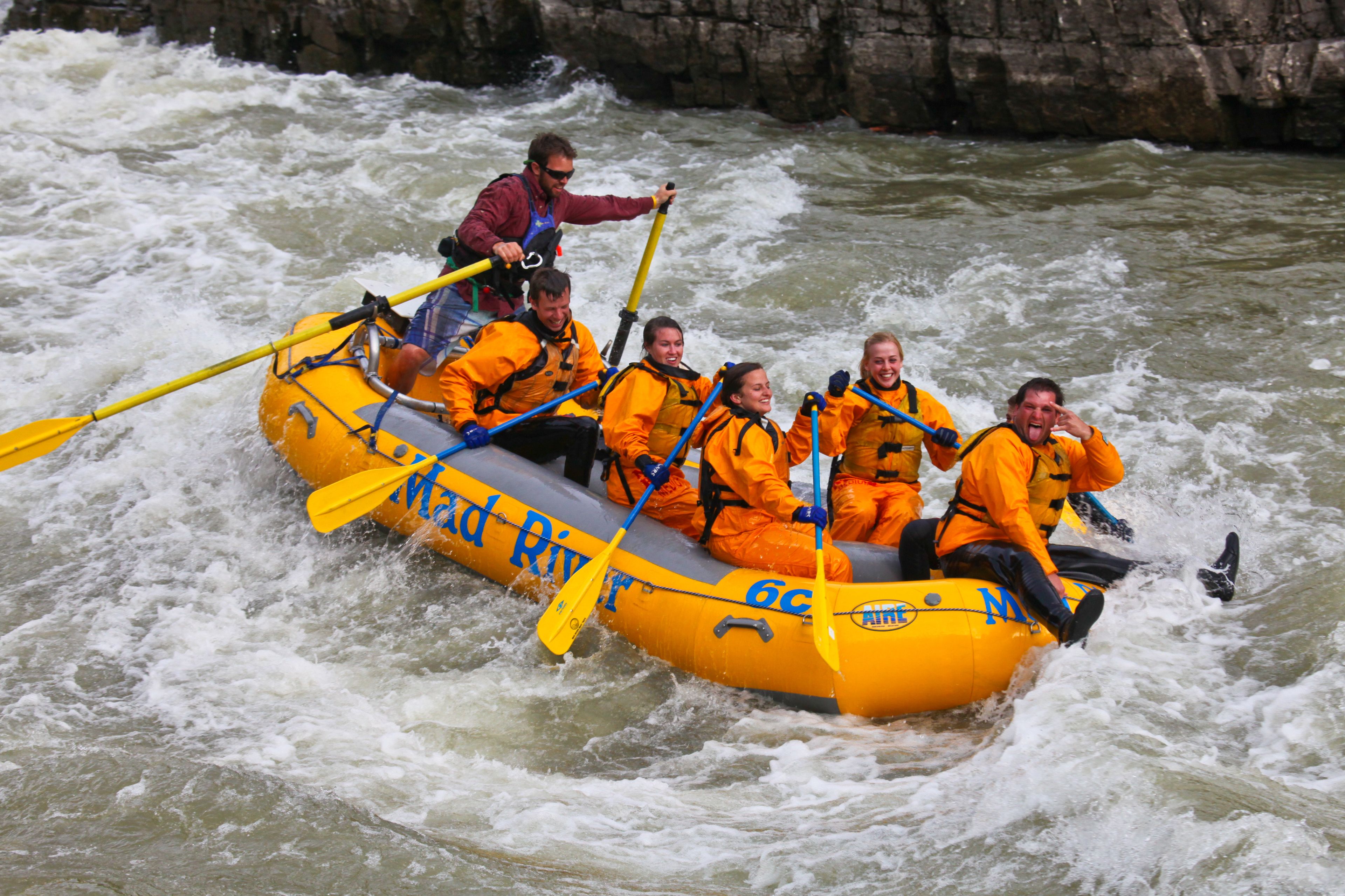 A group of people in a yellow inflatable raft on a river.