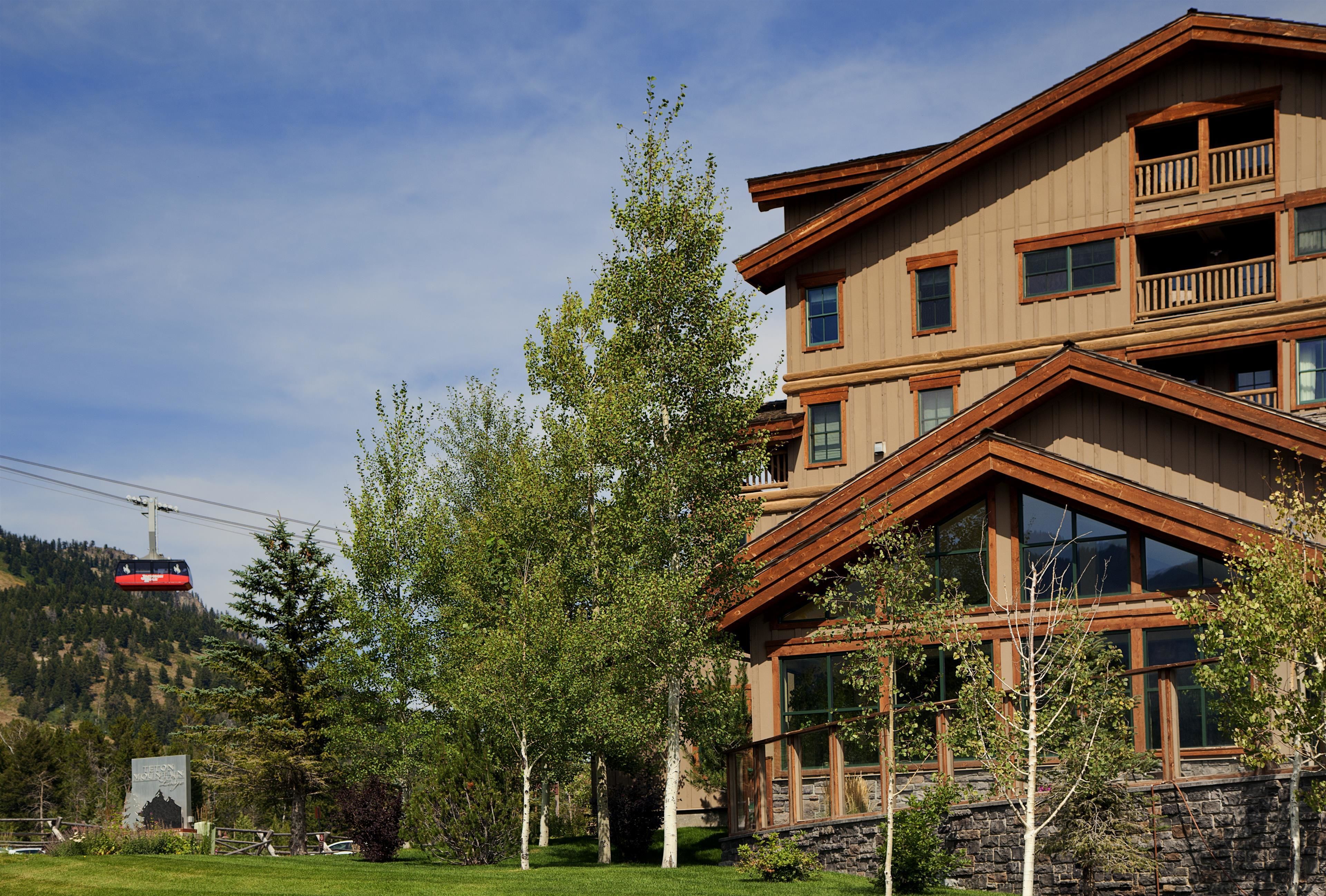 A multi-story building with a stone facade, large windows, and a balcony.
