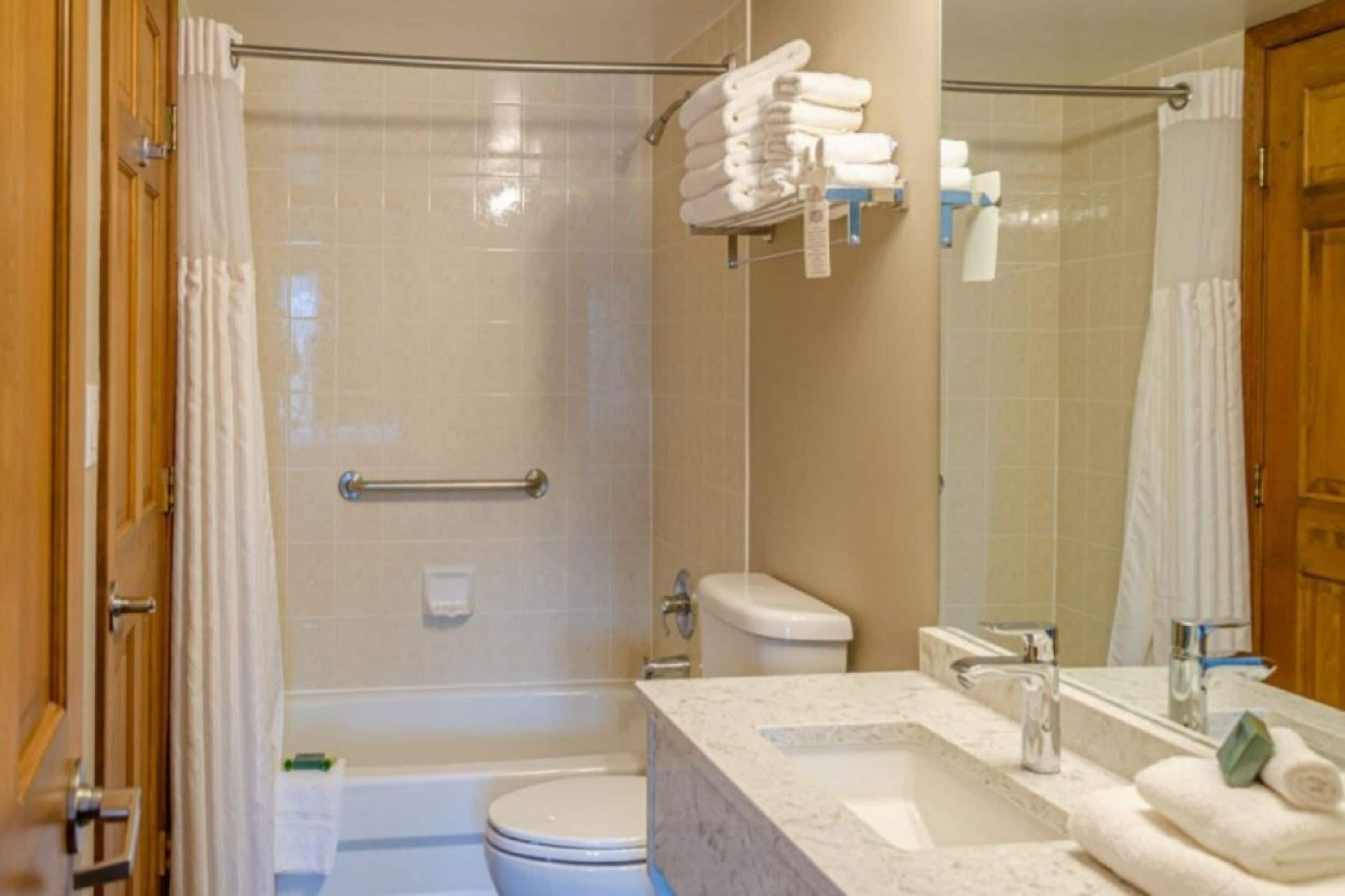 A bathroom with a shower, toilet, and sink.