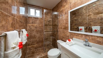 A bathroom with a shower, toilet, and sink.