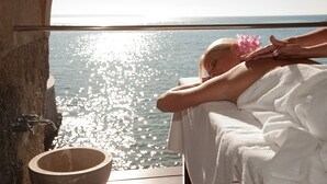 A person receiving a massage with a view of the sea.
