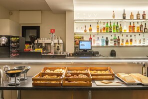 A buffet area with various food items and a bar with a selection of alcoholic beverages. - Hotel Caribou (Pas de la Casa)