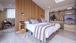 Um quarto moderno com cama, guarda-roupa, escrivaninha e cadeira.