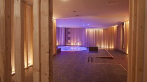 A spa area with a hot tub, wooden paneling, and a tiled floor. - Hotel Piolets Soldeu Centre by Nexta (Soldeu)
