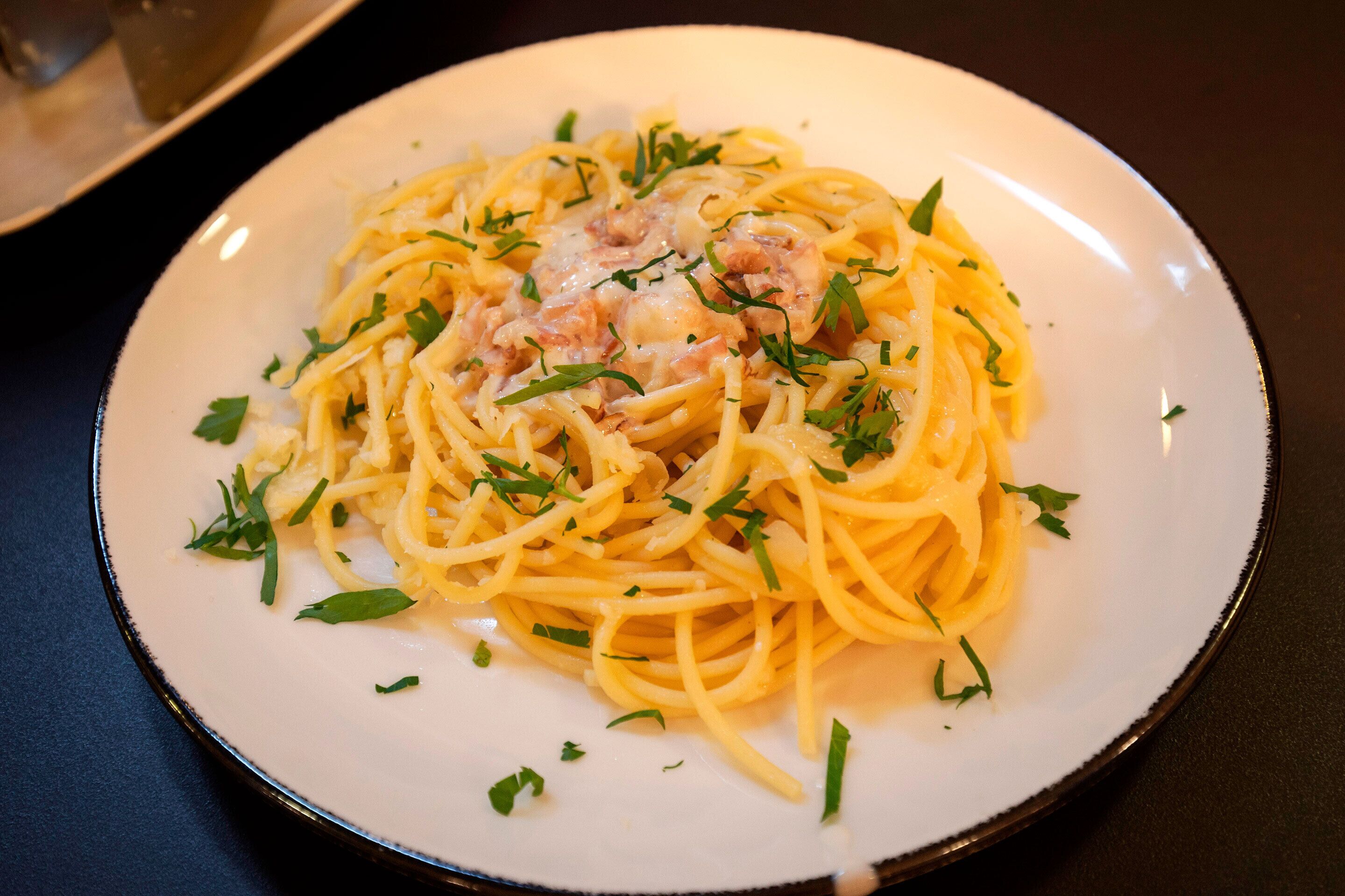 A plate of spaghetti with shrimp and herbs.