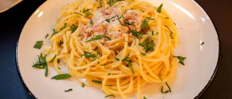 A plate of spaghetti with shrimp and herbs.