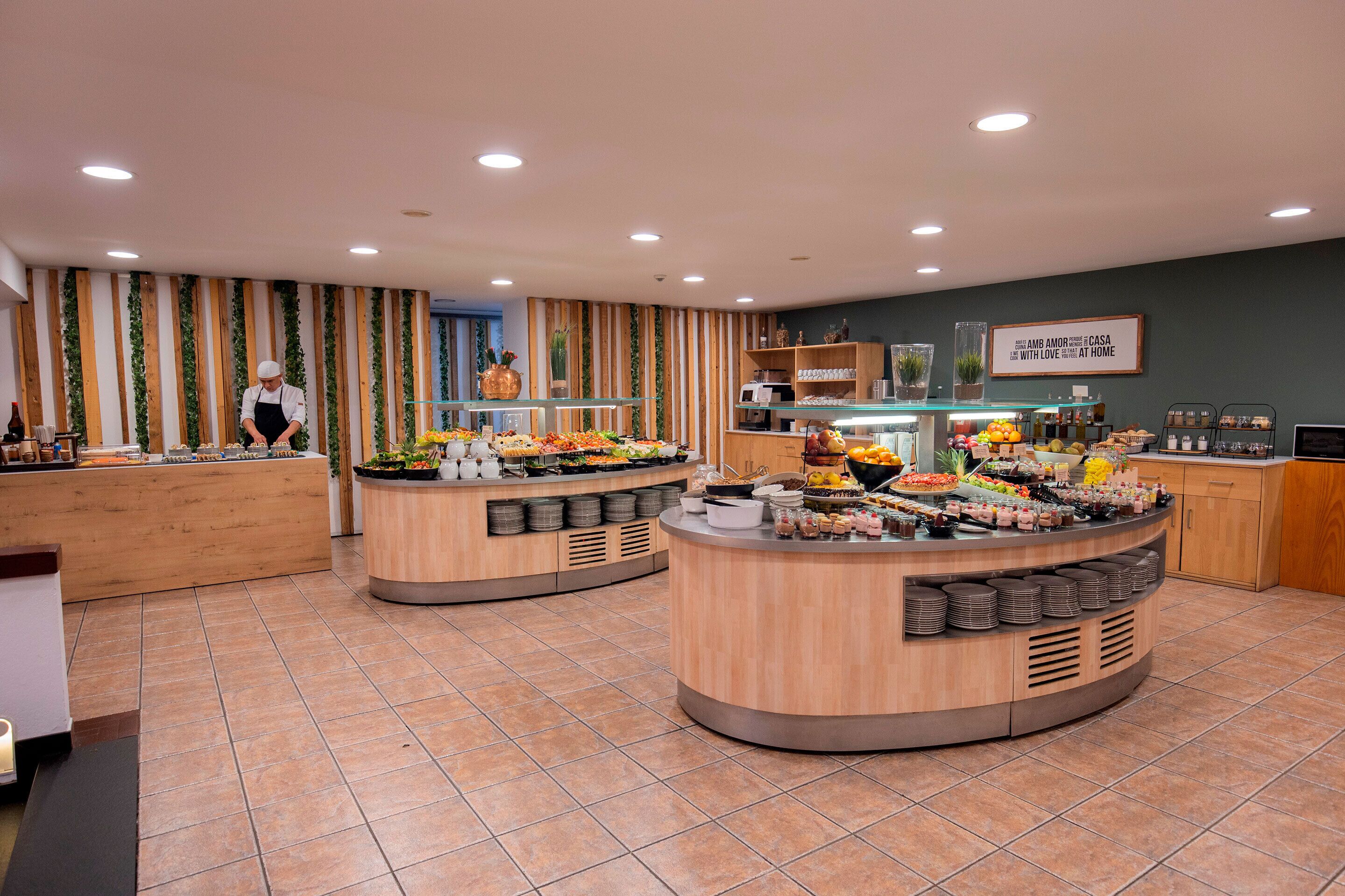 A buffet setup with various food items and a chef preparing food.