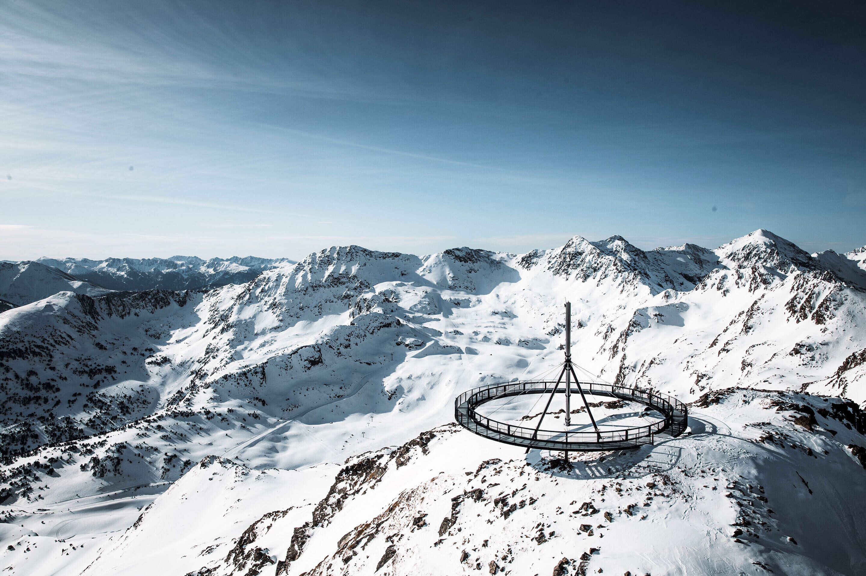 A snow-covered mountain with a circular viewing platform and a tall structure.