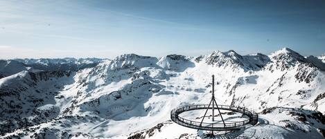 A snow-covered mountain with a circular viewing platform and a tall structure.