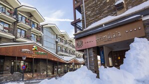 A hotel with multiple floors, balconies, and a snow-covered entrance. - Hotel Piolets Soldeu Centre by Nexta (Soldeu)