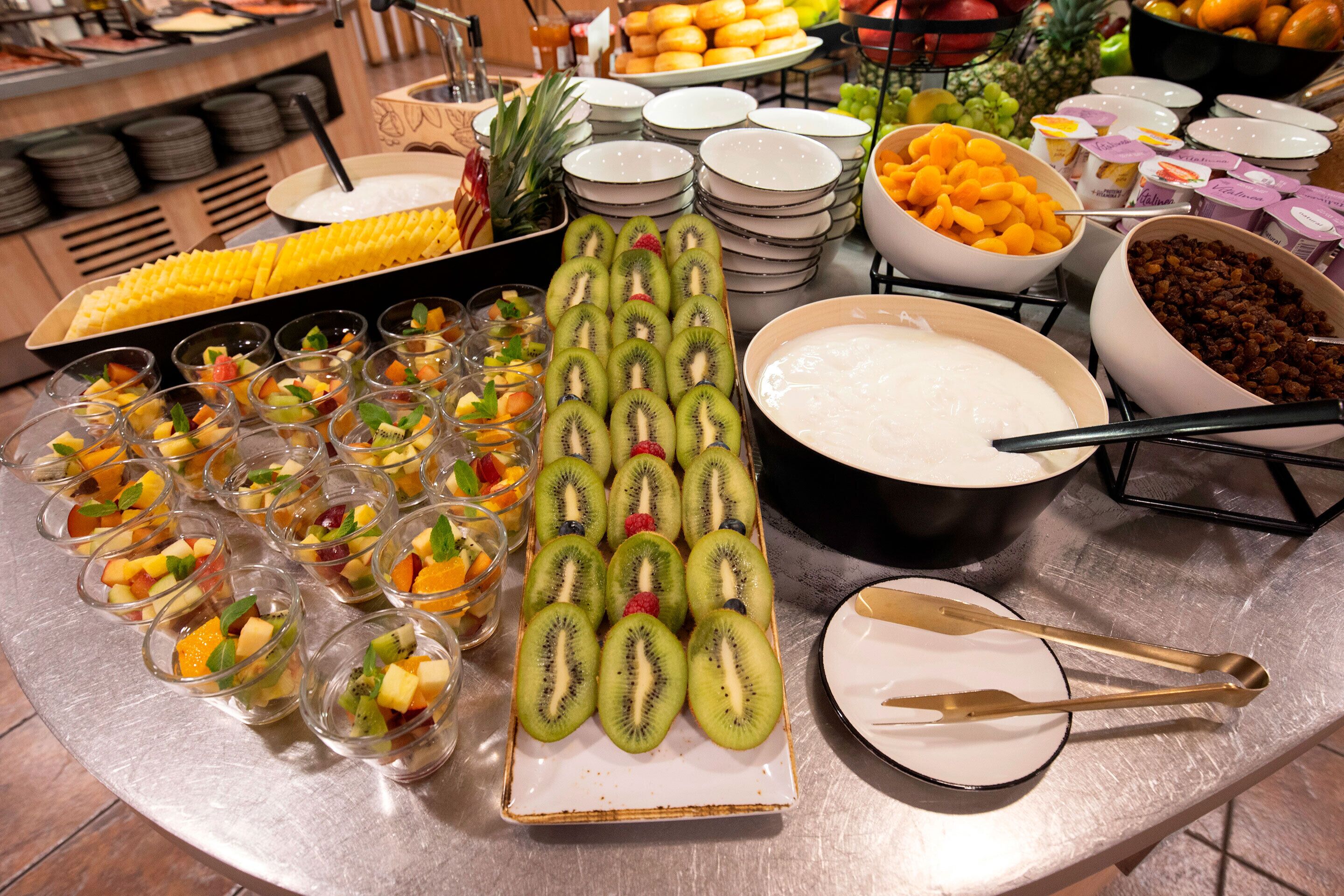 A buffet with various food items including fruits, desserts, and beverages.