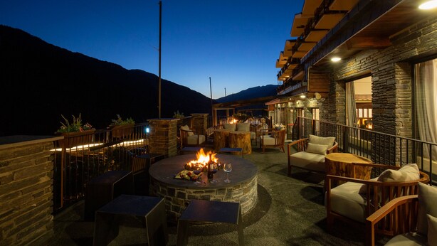 A rooftop patio with a fire pit, outdoor seating, and stone walls. - Hotel Piolets Soldeu Centre by Nexta (Soldeu)