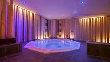 Ein Whirlpool in einem Raum mit Holzlatten an den Wänden und einem gefliesten Boden.