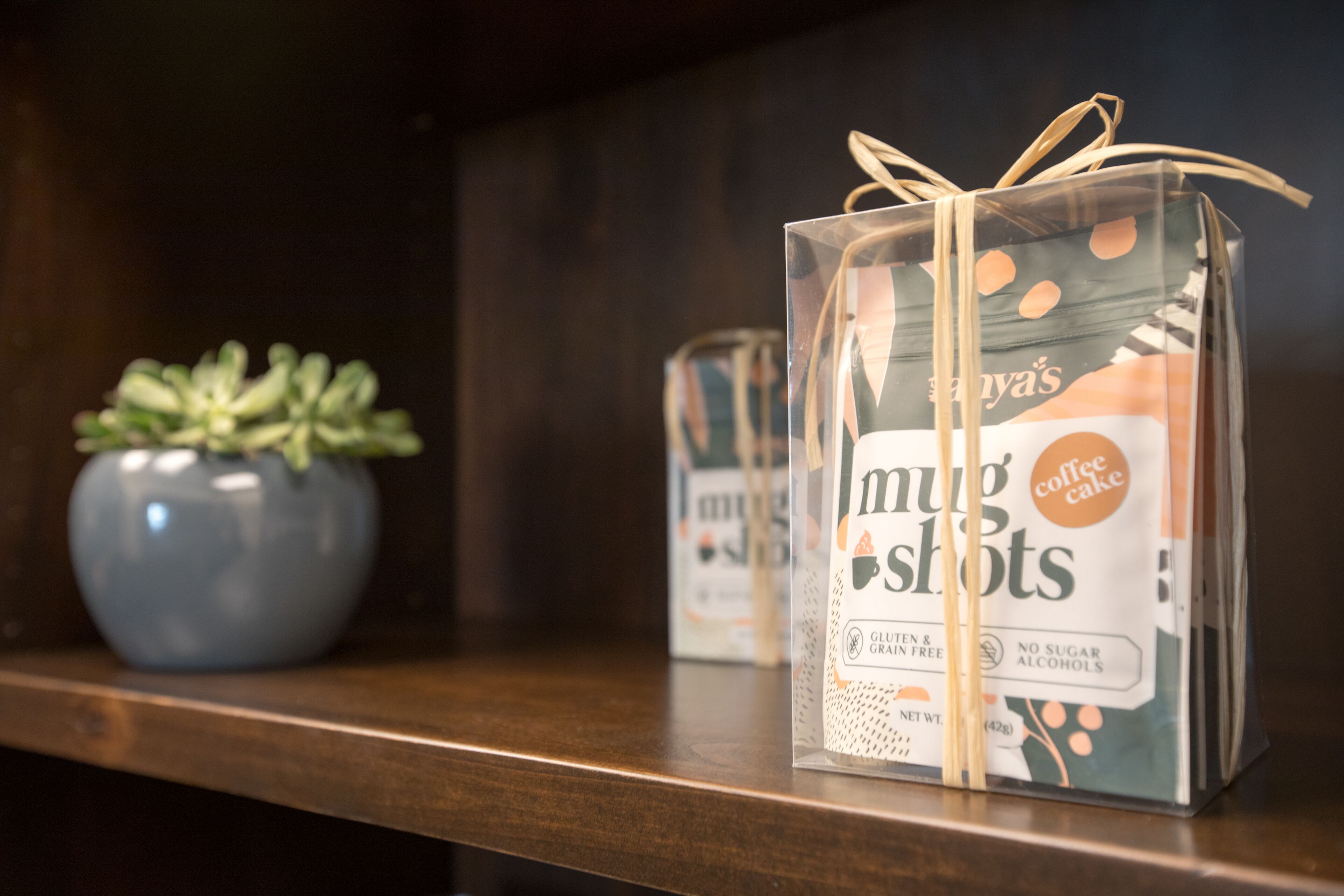 Una caja de regalo con lazo sobre una estantería.
