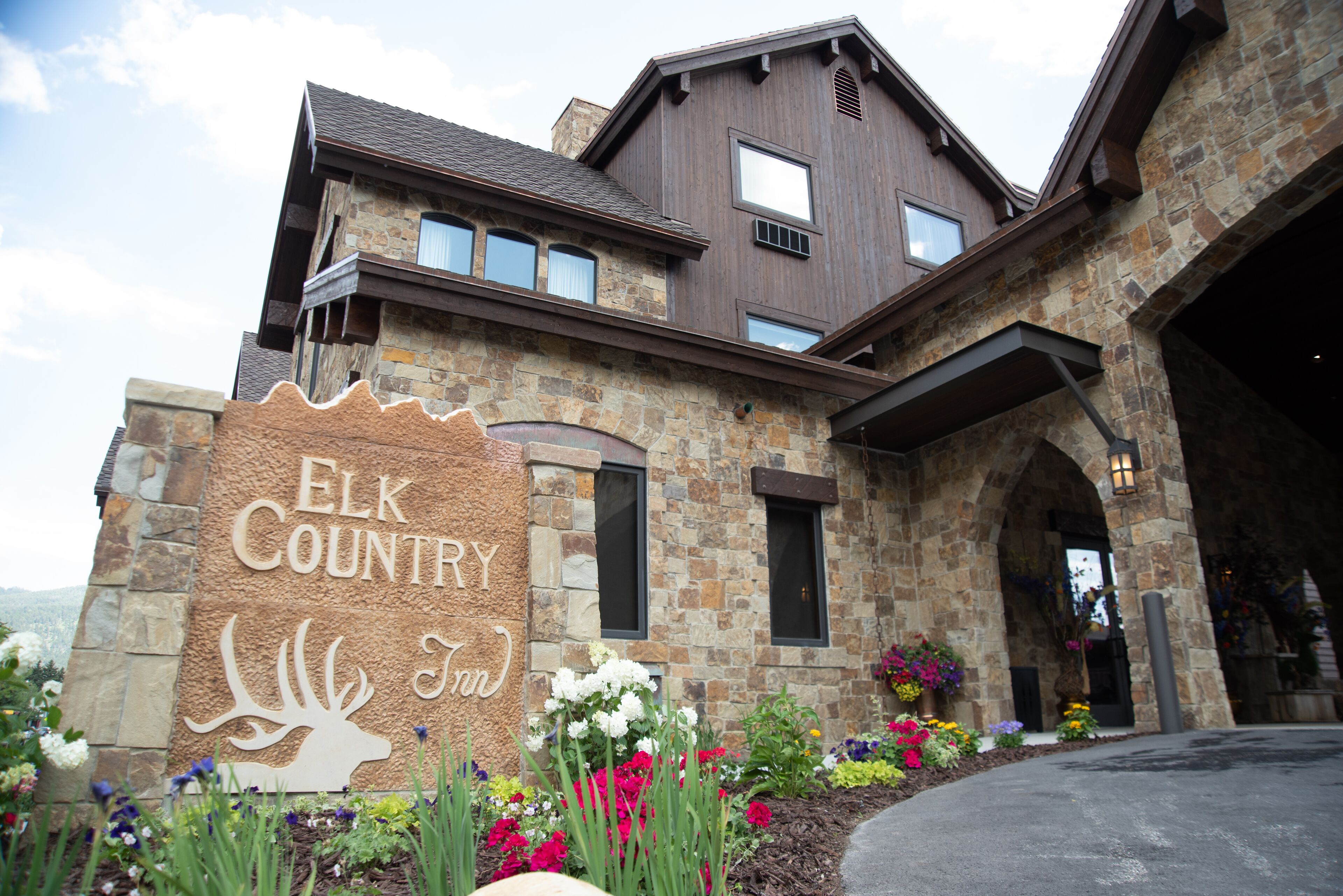 A stone building with a sign reading "Elk Country Inn" and a deer silhouette.