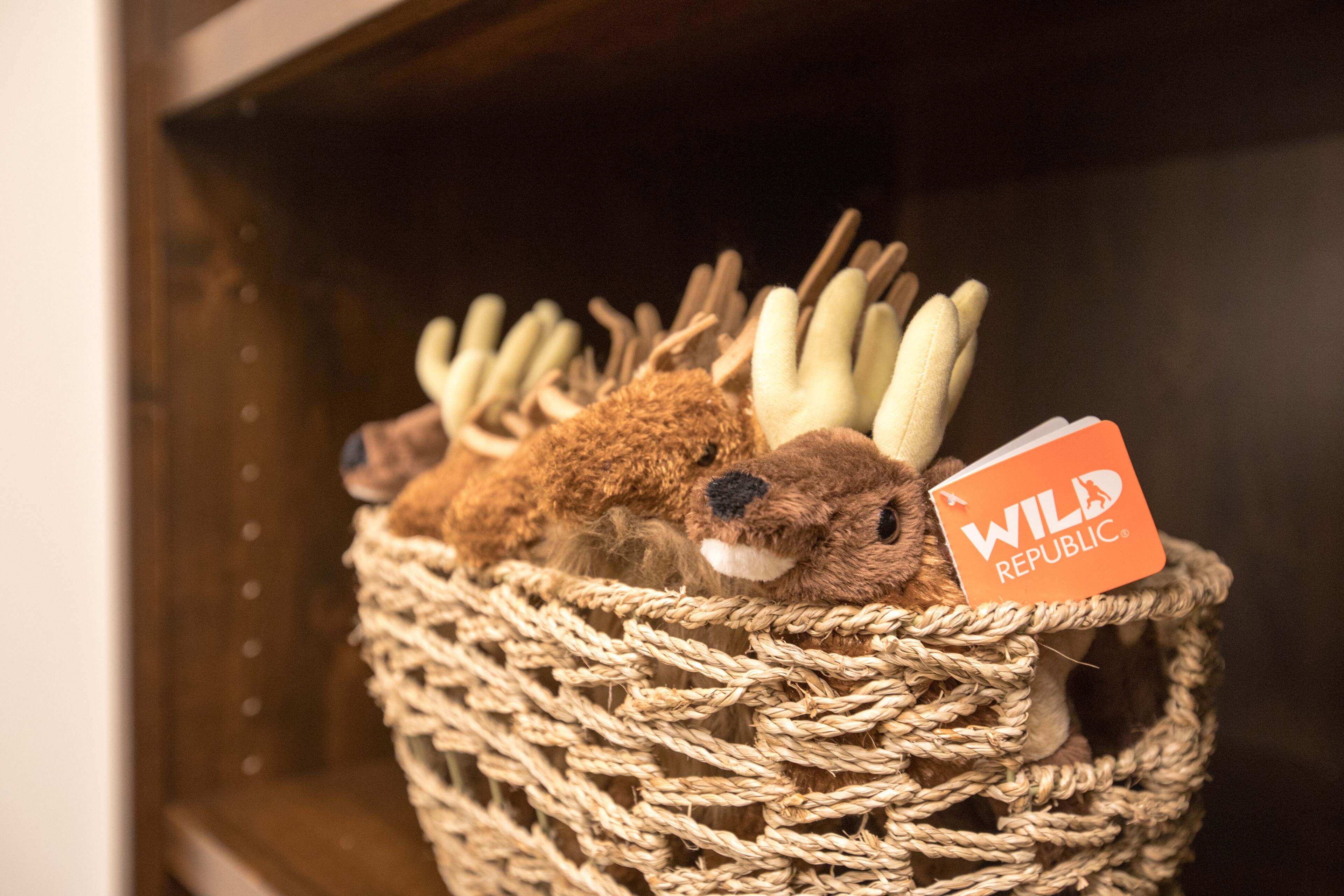 A basket filled with plush toys and a tag labeled "WILD REPUBLIC."