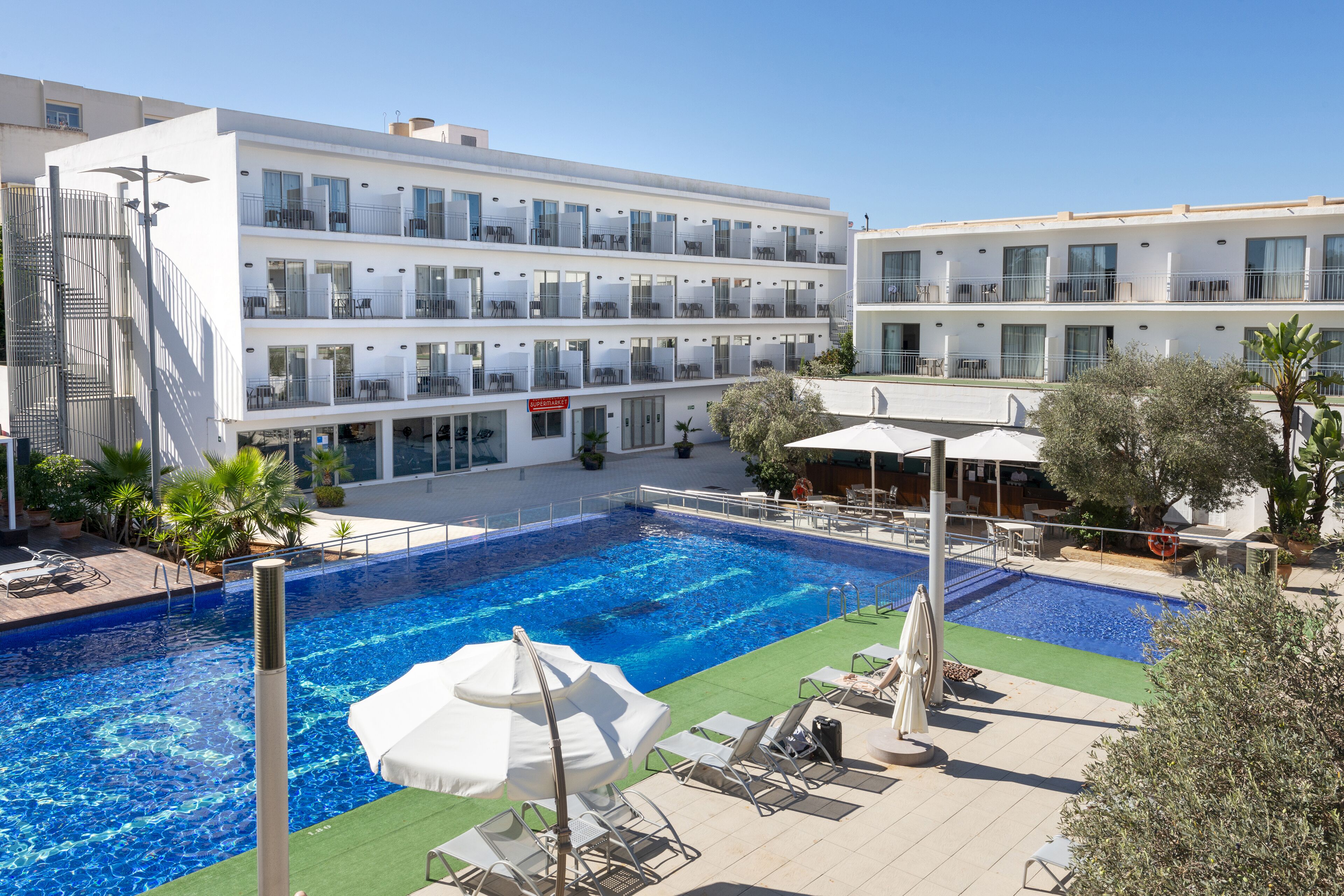 Una piscina al aire libre de temporada, sombrillas