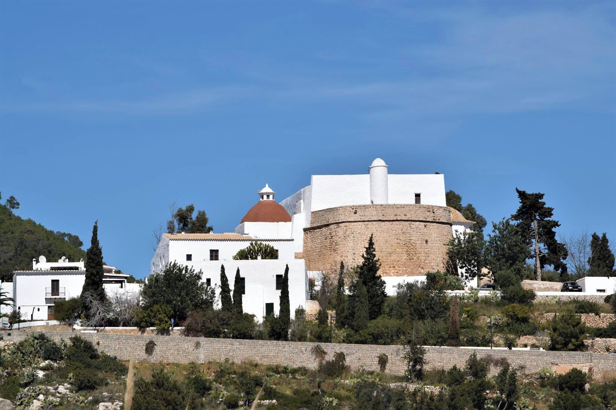A historic building with a round tower, white walls, and a dome.