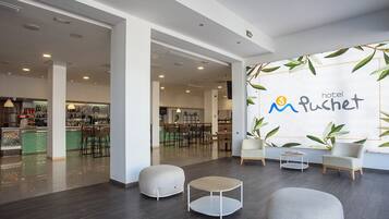 A hotel lobby with a bar area, seating, and a wall with the hotel name.