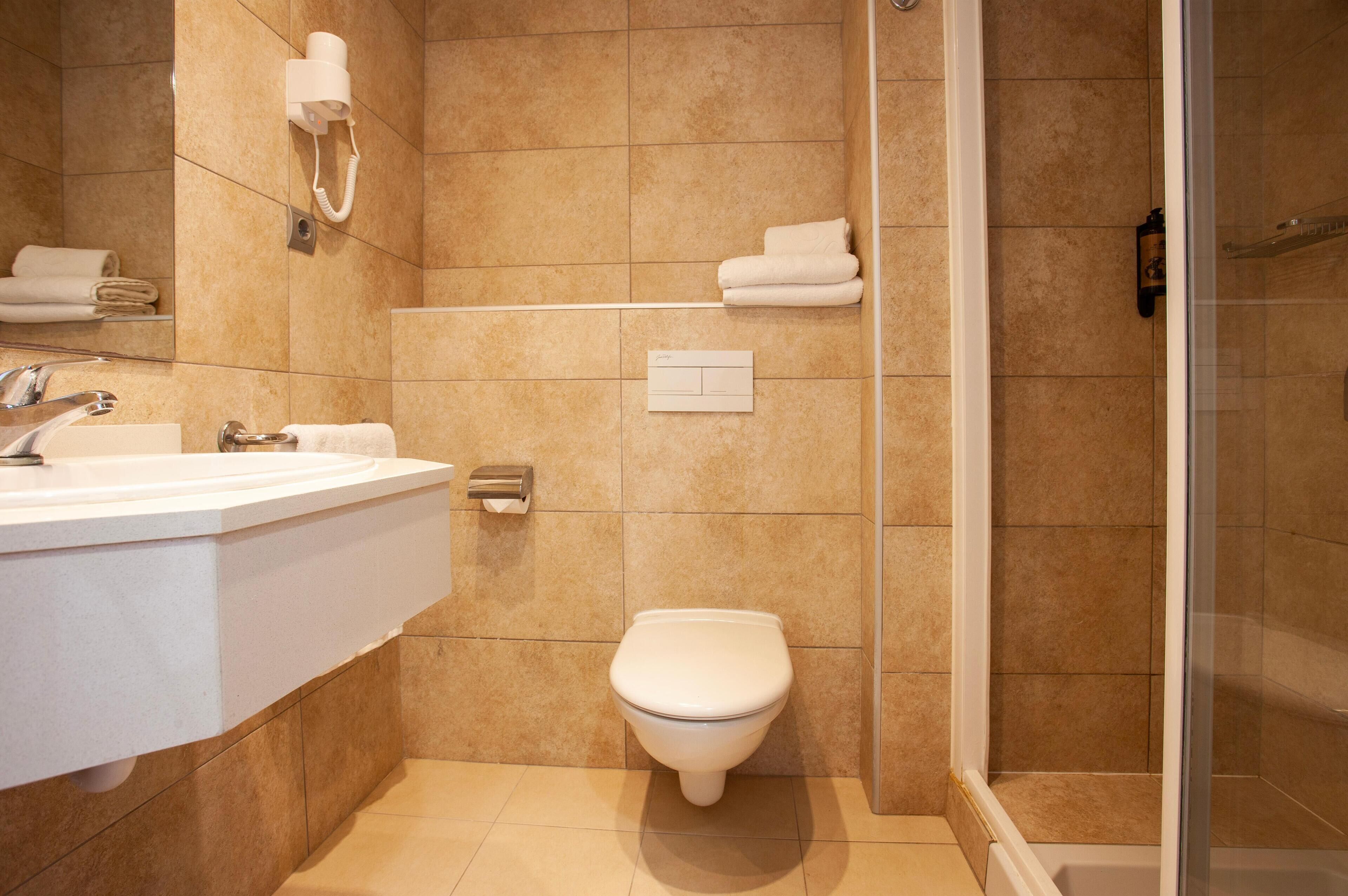 Ein modernes Badezimmer mit Waschbecken, Toilette und Dusche.