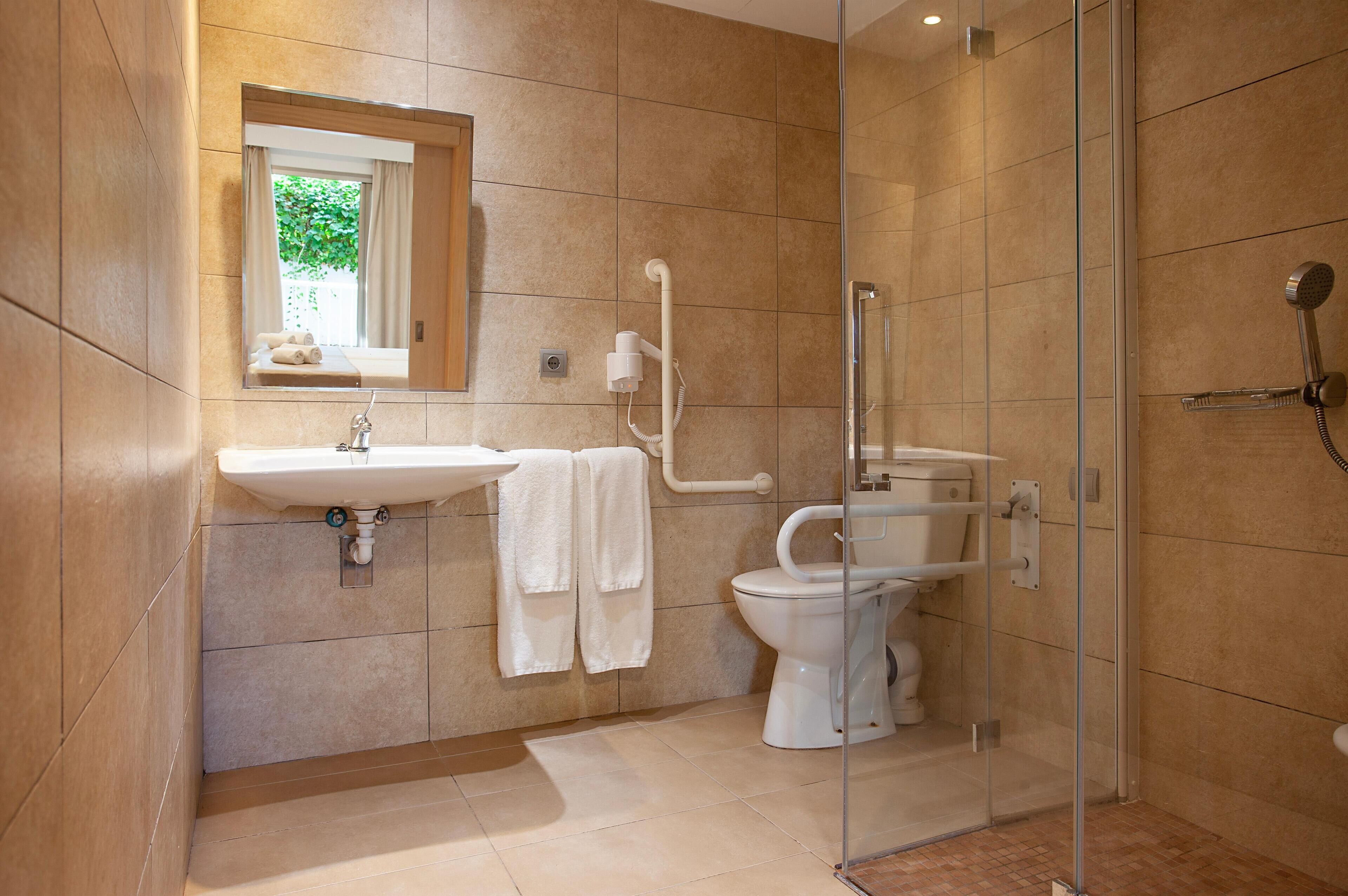 A modern bathroom with a glass-enclosed shower, a sink with a mirror above it, and a toilet.