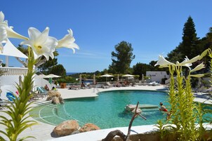 Una piscina al aire libre, sillones reclinables de piscina