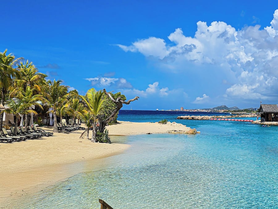 Aan een privéstrand, wit zand, ligstoelen, strandlakens
