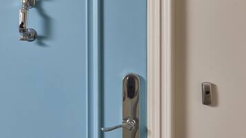 A door with a blue panel and a white panel, featuring a silver handle and a keyhole.