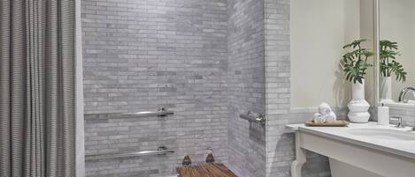 A modern bathroom with a shower, a bathtub, and a vanity with a mirror.