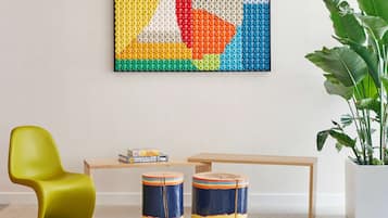 Relax in a stylish space with a vibrant artwork, cozy reading nook, and comfortable seating options.