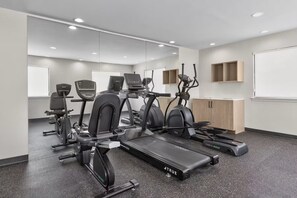 A gym with stationary bikes, treadmills, and a mirrored wall. - Hawthorn Extended Stay by Wyndham DFW Airport North (Irving)