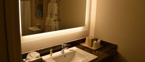A bathroom with a sink, mirror, and towel rack.