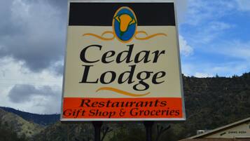 Señal de Cedar Lodge, que indica que ofrece restaurantes, una tienda de regalos y productos de alimentación.
