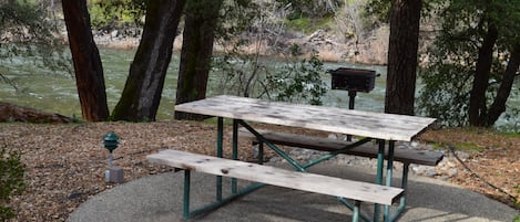 Uma mesa de piquenique com bancos em um parque.