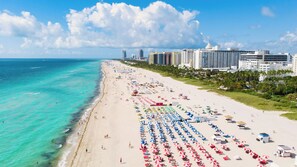 Nær stranden, hvit sand, solsenger og strandhåndklær