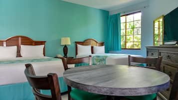 Een hotelkamer met twee bedden, een ronde tafel en stoelen.