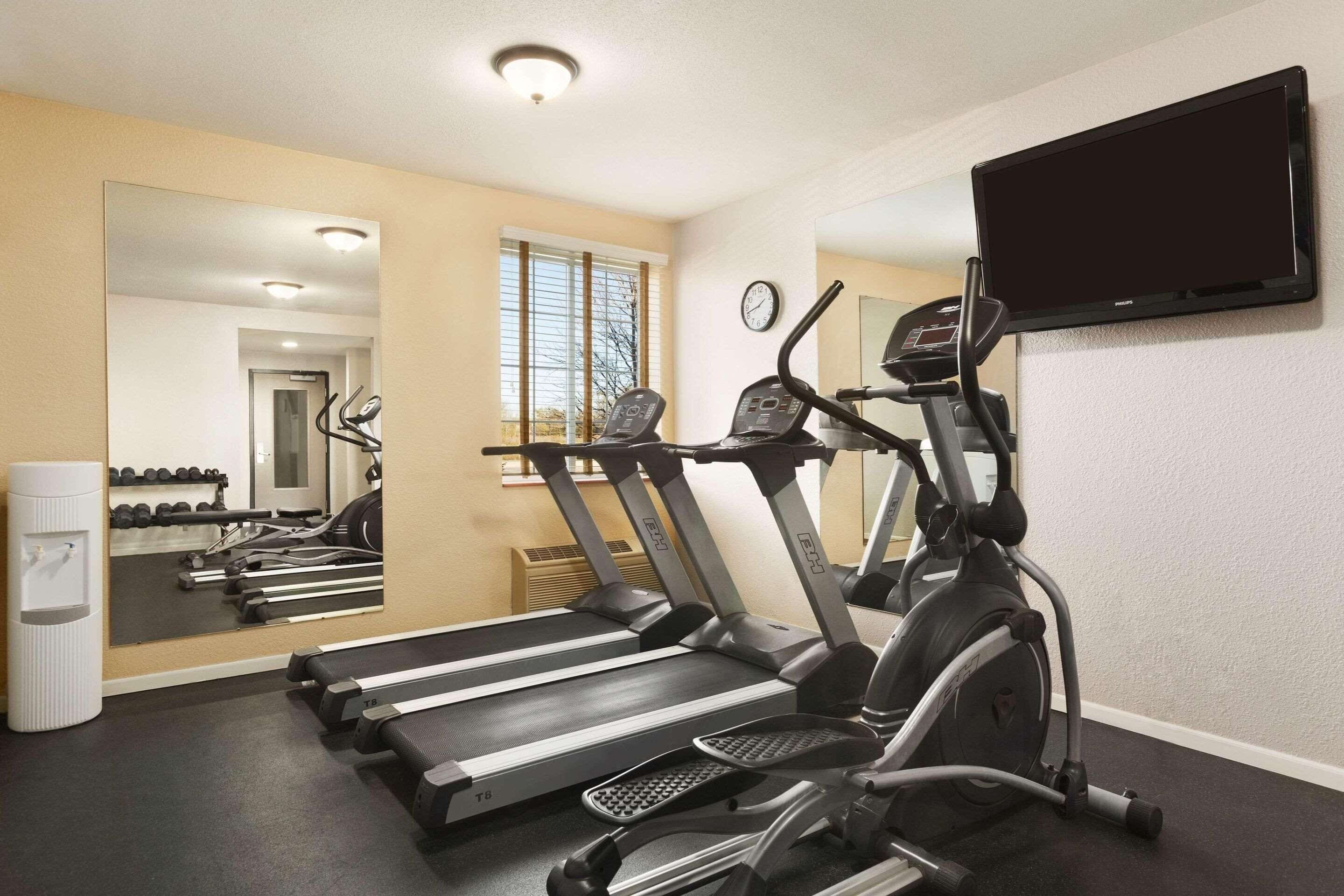 A gym with treadmills, an elliptical, and a stationary bike.