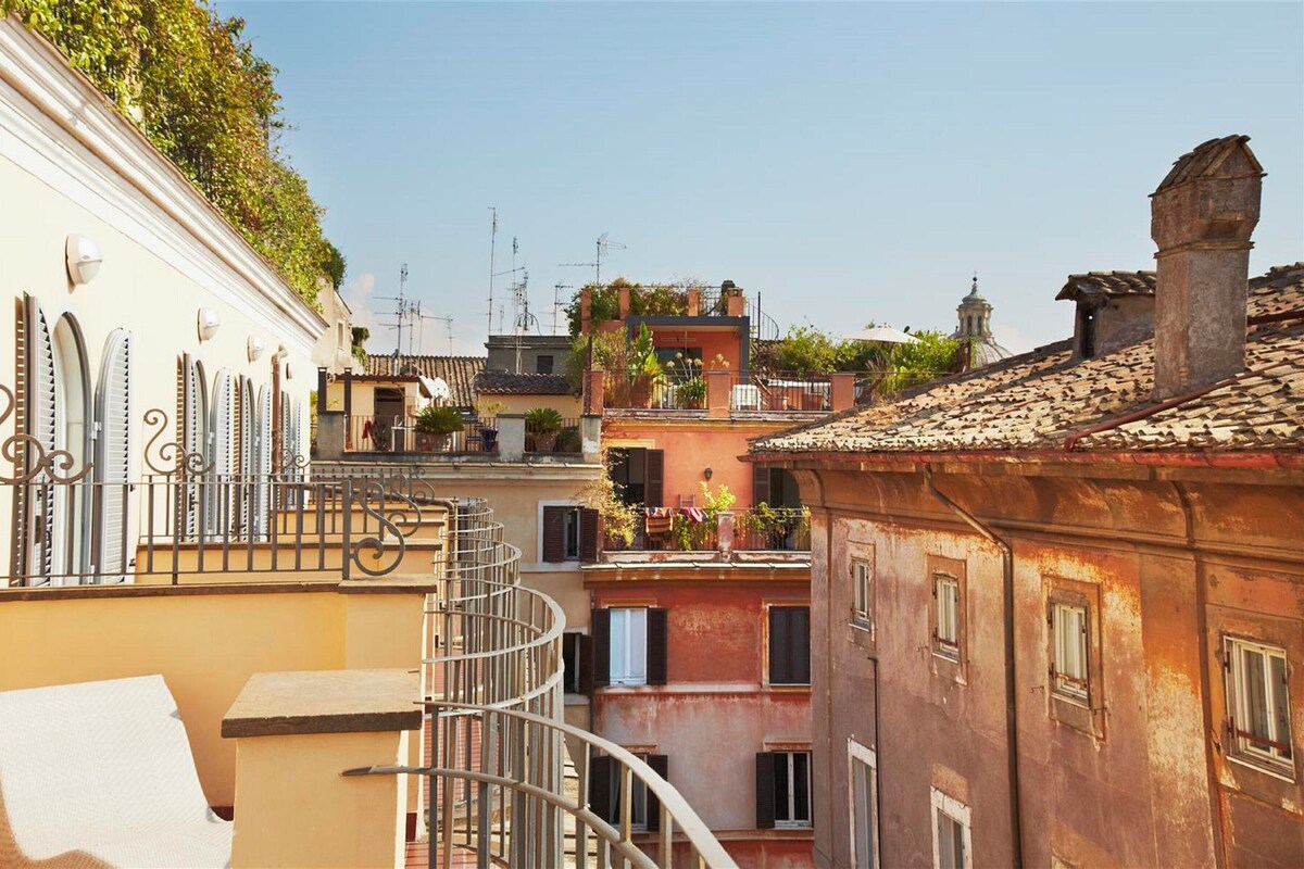 Une rue étroite, bordée de bâtiments des deux côtés, avec des balcons et un escalier en colimaçon.