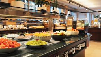 A buffet with various food items and a plant on the counter.