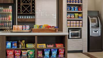 En kiosk med ett urval av färdigförpackade snacks, en vinkyl och en mikrovågsugn.