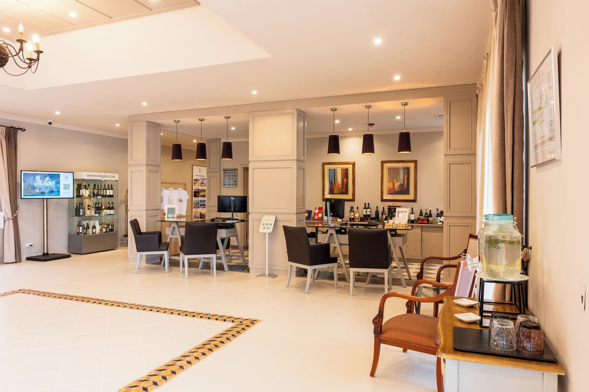 Un hall d’hôtel spacieux comprenant un comptoir d’accueil, un espace salon et un bar.