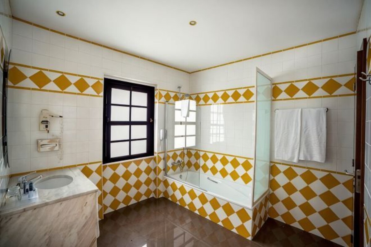 Une salle de bain avec une baignoire, une douche et un lavabo.