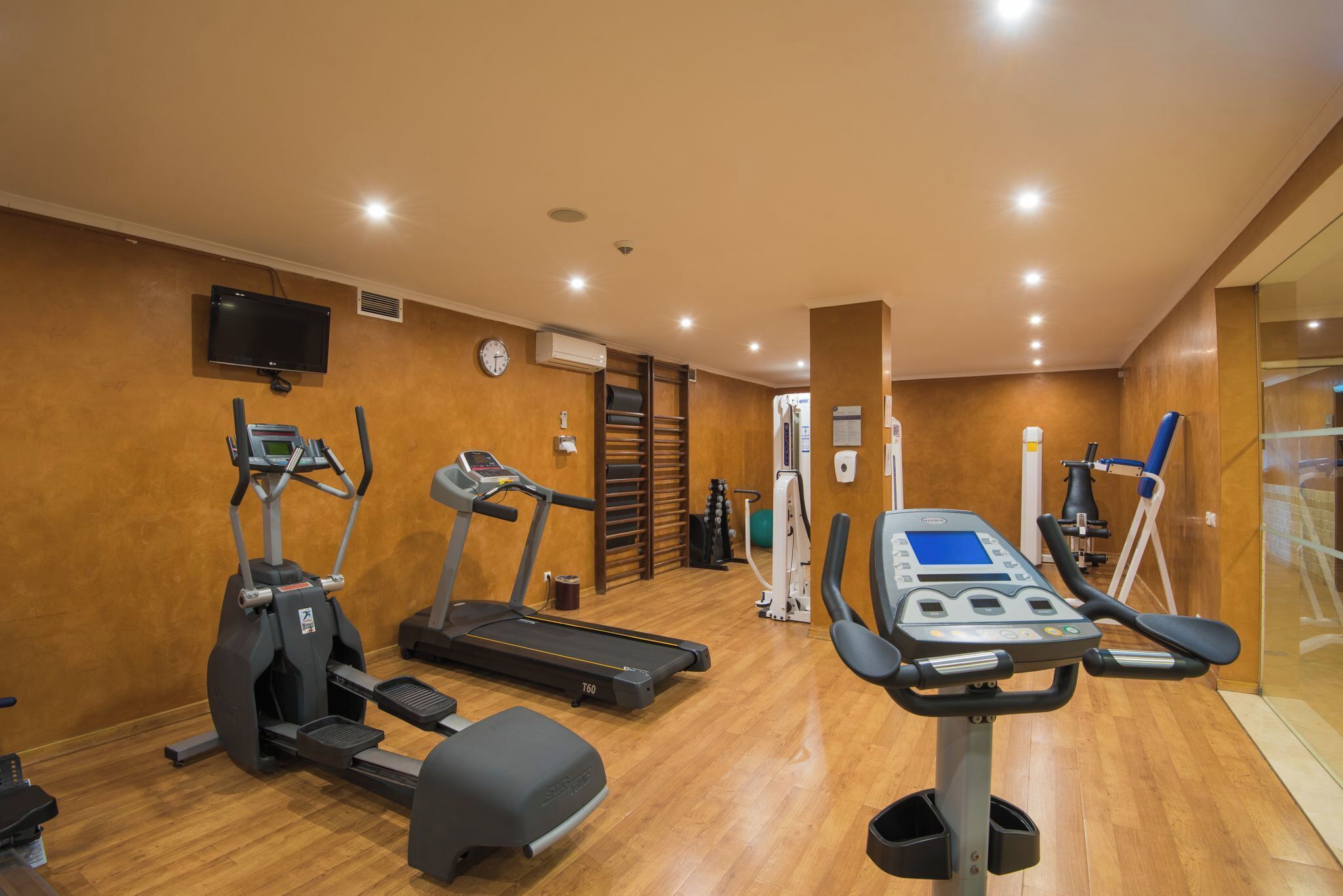 Ein Fitnessstudio mit Laufbändern, Crosstrainern und Rudergeräten.