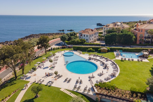Een buitenzwembad, parasols voor strand/zwembad