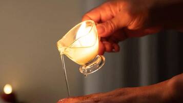 Una mano sosteniendo una vela sobre una superficie.