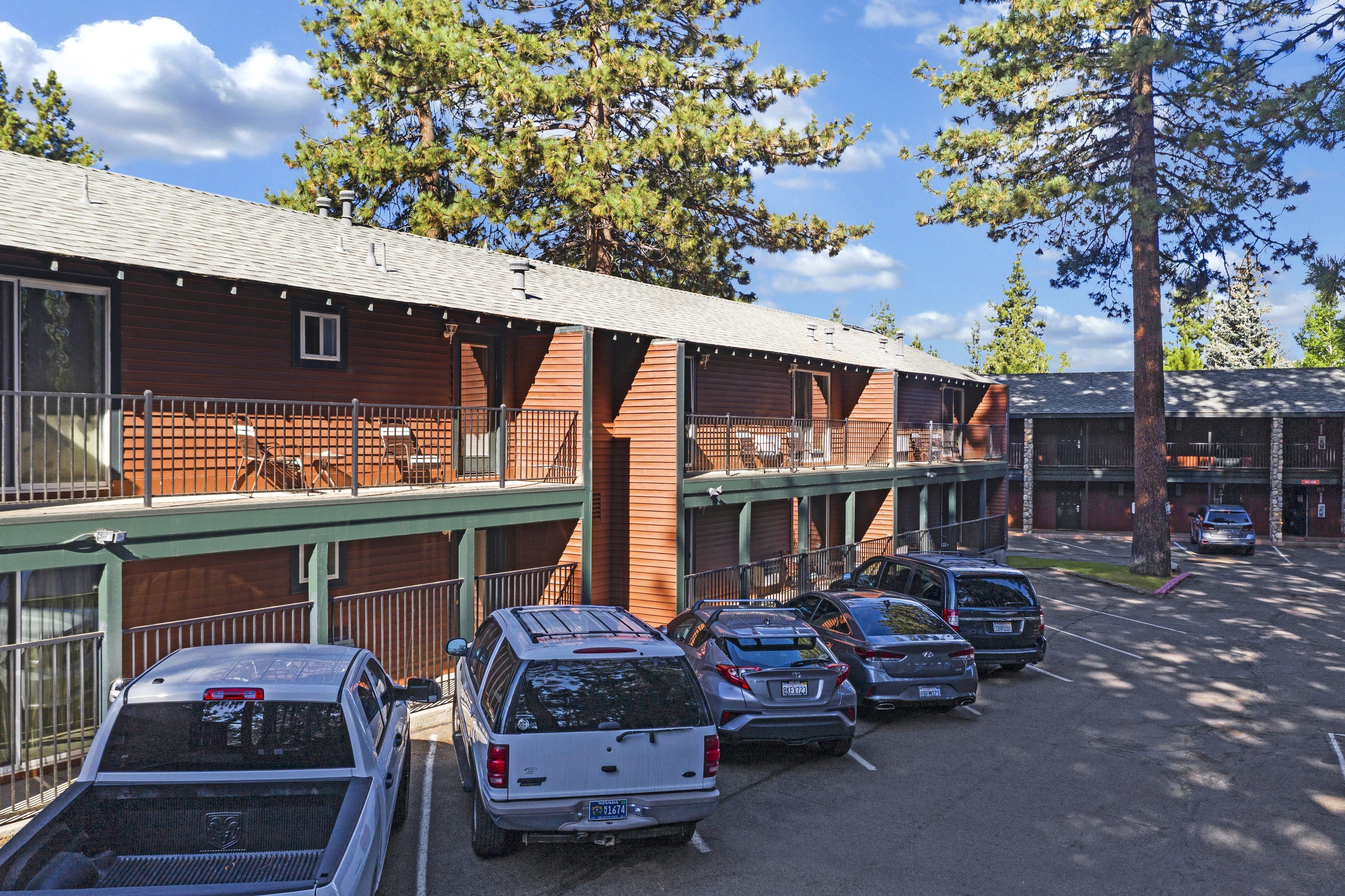 Um motel com área de estacionamento coberta e um edifício com fachada de tijolos.