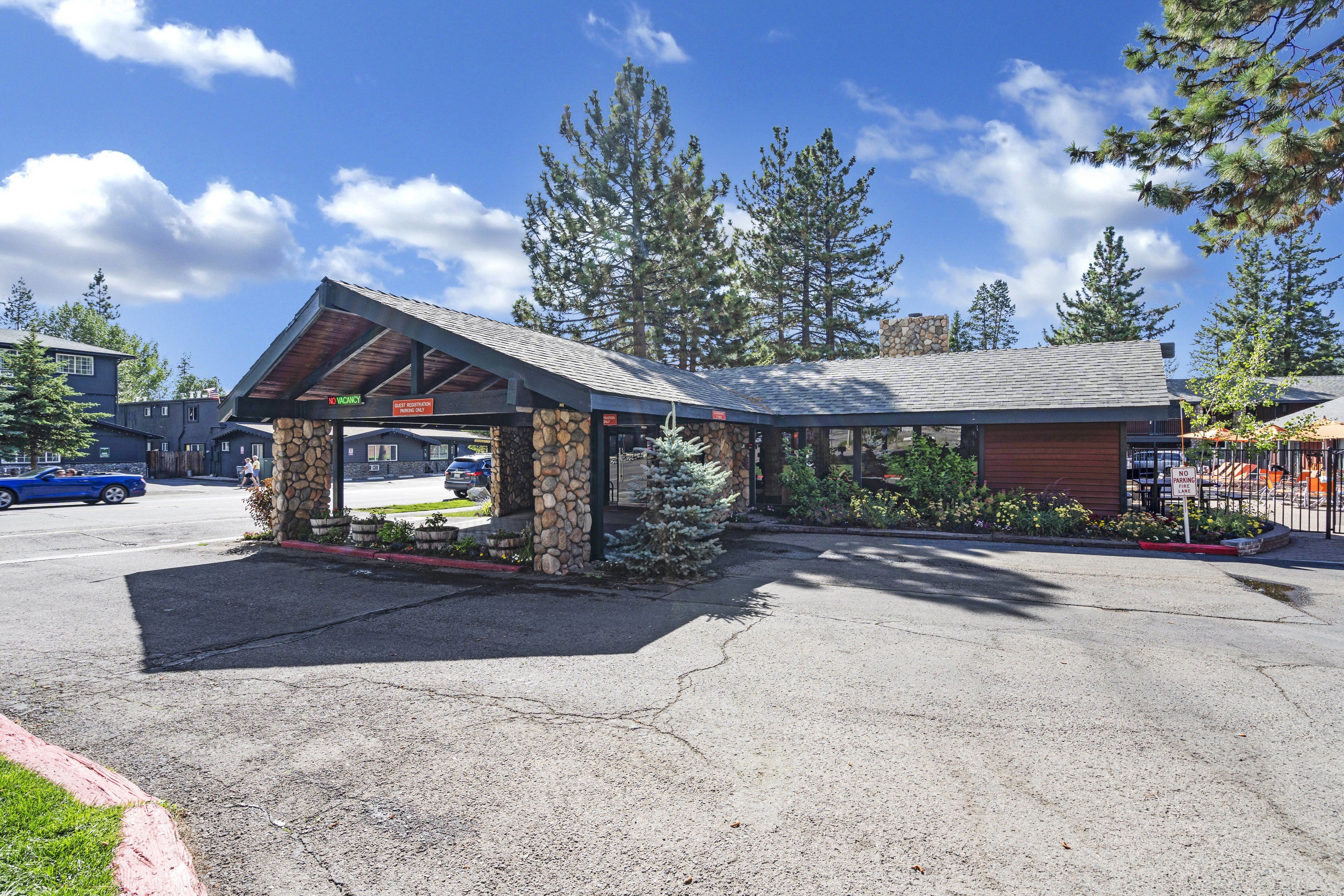 A building with a stone facade, a covered entrance, and a parking lot.